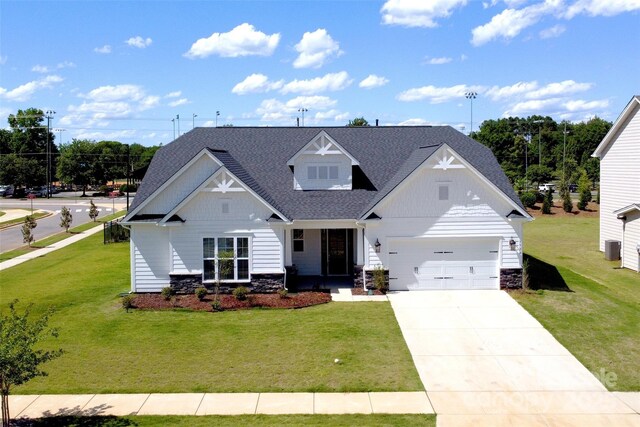3924 Dahlia Dr, Harrisburg, NC 28075 - view of front of house featuring stone siding, a front lawn, and driveway