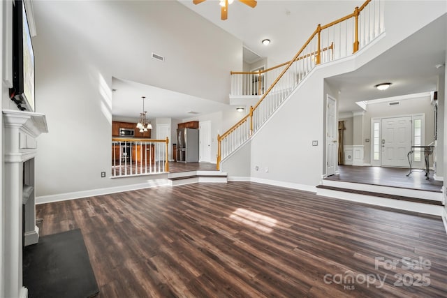 2028 Covered Bridge Ct, Rock Hill, SC 29732 - unfurnished living room with wood finished floors, ceiling fan, a towering ceiling, stairs, and a chandelier
