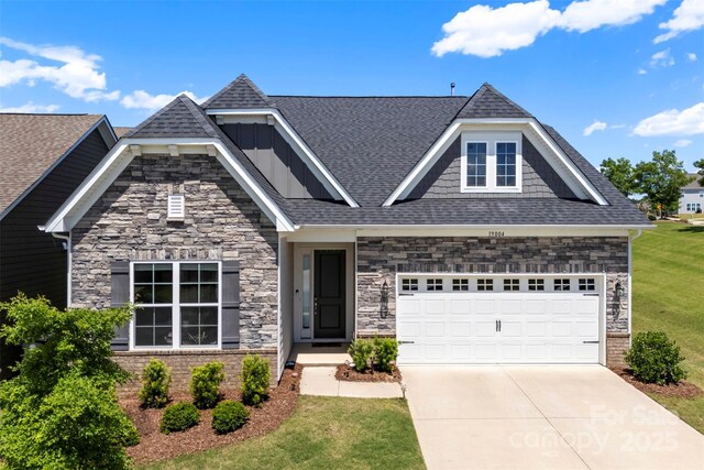 19004 Dry Narrows Way, Charlotte, NC 28278 - view of front of home with concrete driveway, a shingled roof, a front lawn, stone siding, and a garage