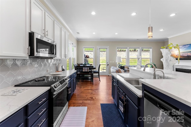 19004 Dry Narrows Way, Charlotte, NC 28278 - kitchen featuring stainless steel appliances, a sink, white cabinets, open floor plan, and blue cabinetry
