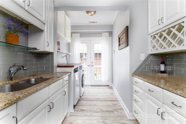 524 Hawthorne Ln, Charlotte, NC 28204 - kitchen featuring a sink, separate washer and dryer, open shelves, tasteful backsplash, and white cabinets