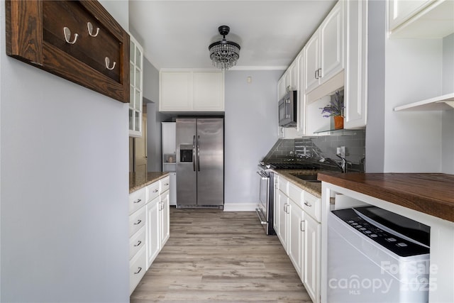 524 Hawthorne Ln, Charlotte, NC 28204 - kitchen featuring stainless steel appliances, a sink, backsplash, dark stone countertops, and white cabinets