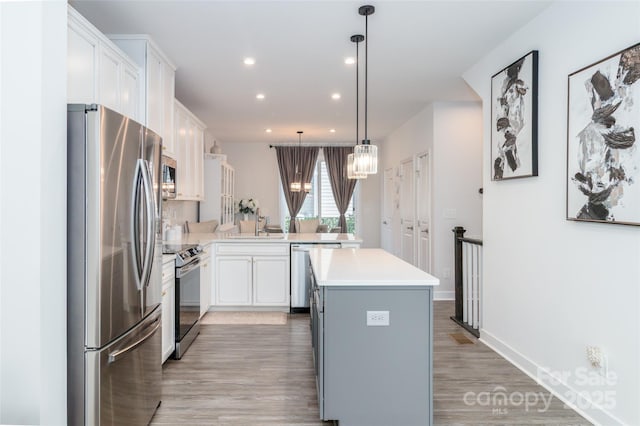 628 Uwharrie River Rd, Charlotte, NC 28211 - kitchen with stainless steel appliances, light wood-style floors, light countertops, white cabinetry, and recessed lighting