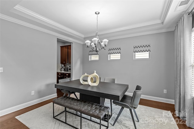 11209 Flenniken Ct, Charlotte, NC 28277 - dining area with a chandelier, crown molding, baseboards, dark wood-style floors, and a tray ceiling