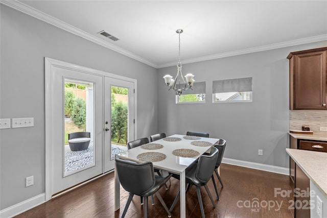 11209 Flenniken Ct, Charlotte, NC 28277 - dining area featuring crown molding, dark wood-style flooring, a chandelier, baseboards, and french doors