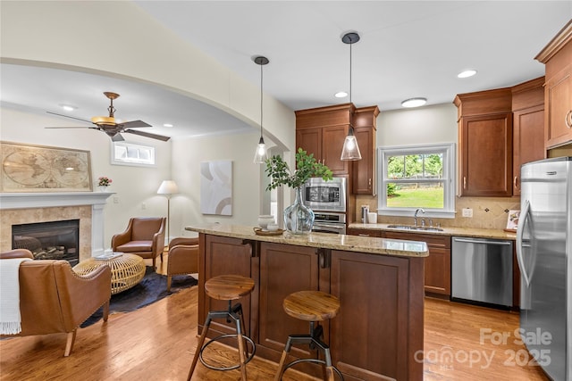 1500 Lynway Dr, Charlotte, NC 28203 - kitchen with stainless steel appliances, a sink, ceiling fan, light wood-style flooring, and tasteful backsplash