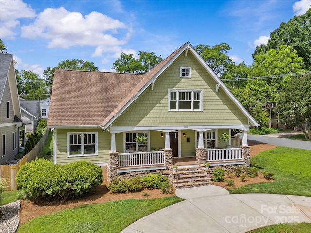 1500 Lynway Dr, Charlotte, NC 28203 - craftsman-style home with a porch, roof with shingles, and stone siding