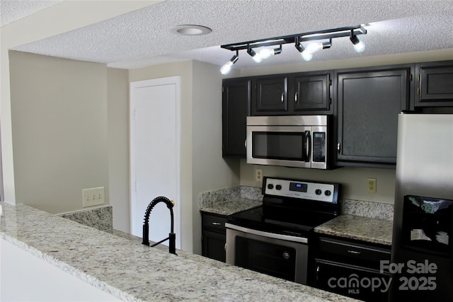 1604 Arlyn Cir Unit E, Charlotte, NC 28213 - kitchen with stainless steel appliances, dark cabinets, a textured ceiling, and light stone counters