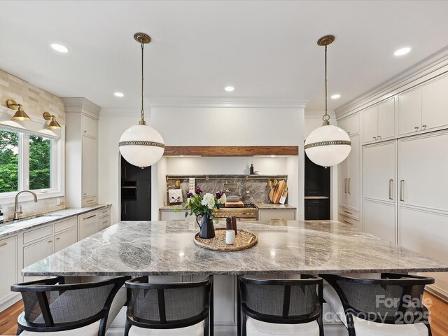 735 Davidson Run Ln, Davidson, NC 28036 - kitchen featuring a sink, light stone countertops, a spacious island, white cabinetry, and recessed lighting