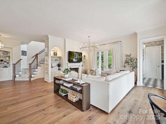 735 Davidson Run Ln, Davidson, NC 28036 - living area with ornamental molding, light wood-style flooring, stairs, built in shelves, and a chandelier