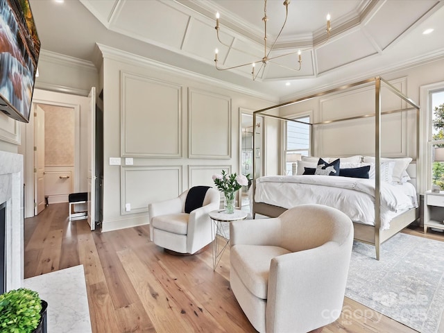 735 Davidson Run Ln, Davidson, NC 28036 - bedroom featuring a decorative wall, crown molding, light wood finished floors, a chandelier, and a fireplace