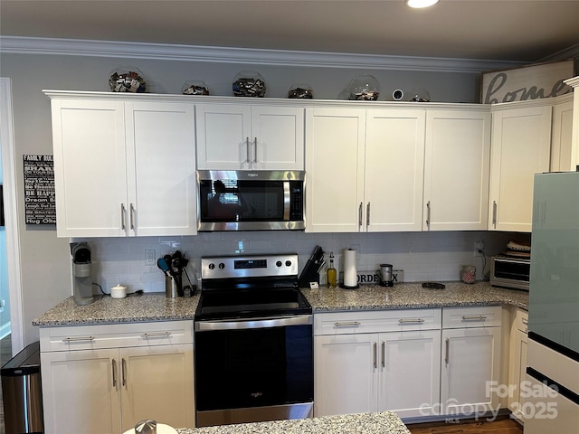 110 W Pine St, Lincolnton, NC 28092 - kitchen featuring stainless steel appliances, white cabinets, decorative backsplash, crown molding, and light stone countertops