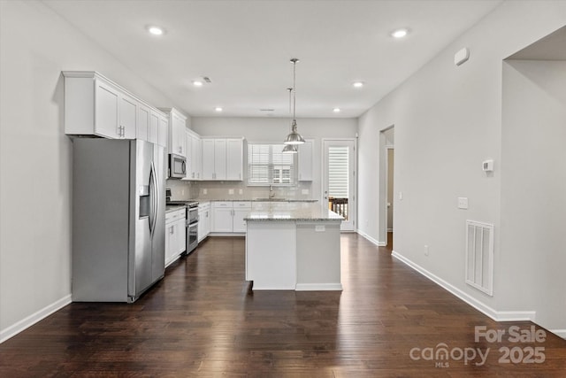 1142 Doveridge St, Charlotte, NC 28273 - kitchen with appliances with stainless steel finishes, a sink, dark wood finished floors, white cabinets, and a kitchen island
