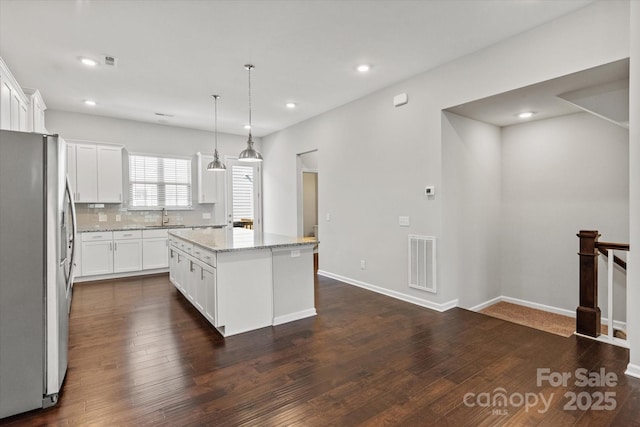1142 Doveridge St, Charlotte, NC 28273 - kitchen with freestanding refrigerator, a sink, dark wood-style floors, a kitchen island, and white cabinets