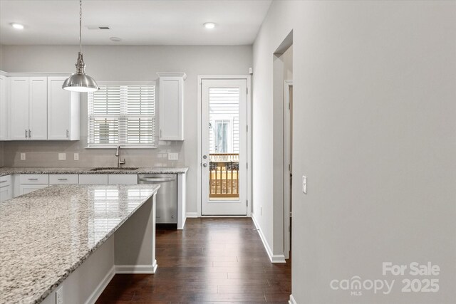 1142 Doveridge St, Charlotte, NC 28273 - kitchen featuring stainless steel dishwasher, a sink, dark wood-style flooring, white cabinets, and decorative light fixtures