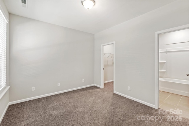 1142 Doveridge St, Charlotte, NC 28273 - unfurnished bedroom featuring light colored carpet, a walk in closet, multiple windows, and baseboards