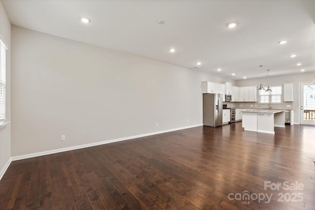 1142 Doveridge St, Charlotte, NC 28273 - unfurnished living room with dark wood-style floors, baseboards, recessed lighting, and a chandelier