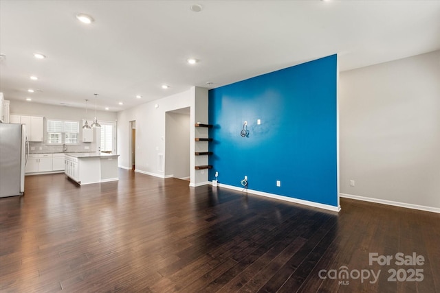 1142 Doveridge St, Charlotte, NC 28273 - unfurnished living room featuring recessed lighting, dark wood-style floors, baseboards, and a sink