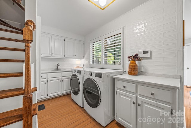 15 Old Stage Trl, Clover, SC 29710 - laundry room featuring washer and dryer, light wood-style flooring, and cabinet space