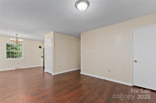 25 Evelake Dr, Asheville, NC 28806 - spare room with dark wood-style floors, a chandelier, a textured ceiling, and baseboards