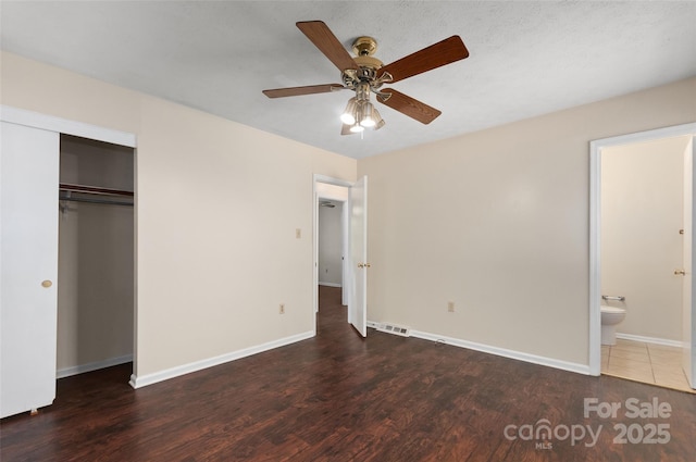 25 Evelake Dr, Asheville, NC 28806 - unfurnished bedroom featuring wood finished floors, baseboards, a closet, connected bathroom, and a ceiling fan