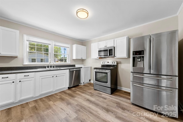2009 Auten Rd, Gastonia, NC 28054 - kitchen featuring stainless steel appliances, a sink, ornamental molding, dark countertops, and white cabinetry
