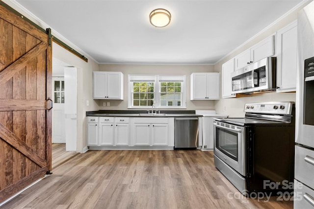 2009 Auten Rd, Gastonia, NC 28054 - kitchen featuring stainless steel appliances, a sink, white cabinets, light wood-style flooring, and crown molding