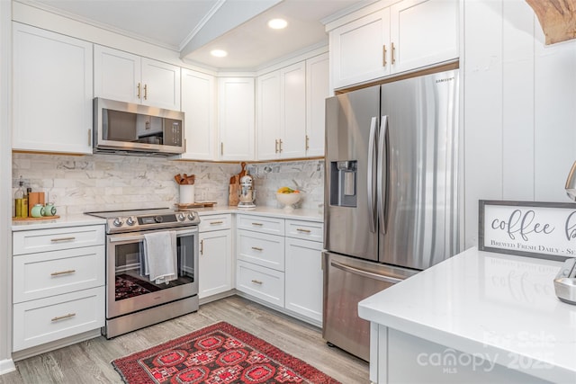 5114 Leisure Ln, Sherrills Ford, NC 28673 - kitchen featuring appliances with stainless steel finishes, light wood-style floors, white cabinetry, decorative backsplash, and ornamental molding