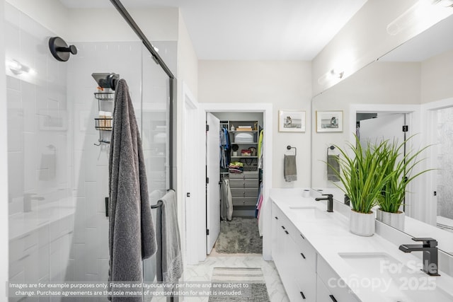 113 Verbena St NE Unit 11, Charlotte, NC 28217 - bathroom featuring a shower stall, marble look tiles, double vanity, and a spacious closet