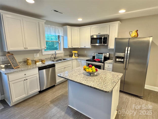 212 Old Centergrove Rd, Kannapolis, NC 28083 - kitchen with stainless steel appliances, a sink, light wood-style floors, white cabinets, and recessed lighting