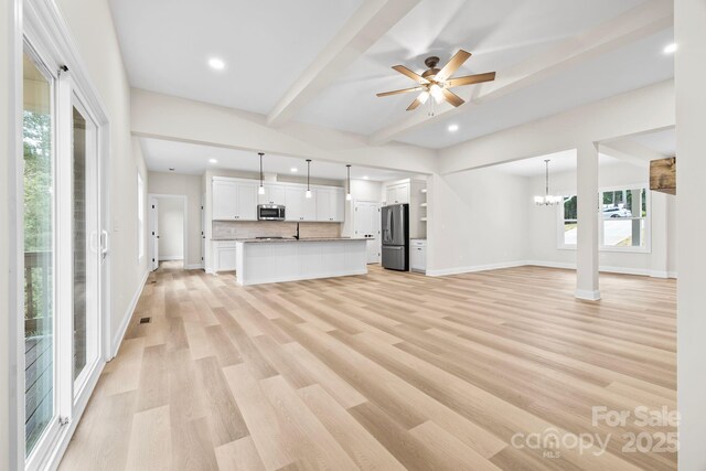 5025 Harbor View Dr E, Granite Falls, NC 28630 - unfurnished living room featuring plenty of natural light, light wood-type flooring, beamed ceiling, baseboards, and recessed lighting