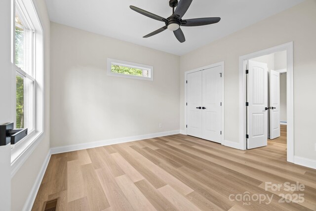 5025 Harbor View Dr E, Granite Falls, NC 28630 - unfurnished bedroom with light wood-style floors, baseboards, ceiling fan, and a closet