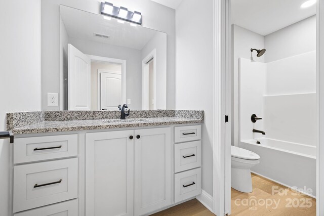 5025 Harbor View Dr E, Granite Falls, NC 28630 - bathroom featuring toilet, vanity, shower / bathtub combination, wood finished floors, and baseboards