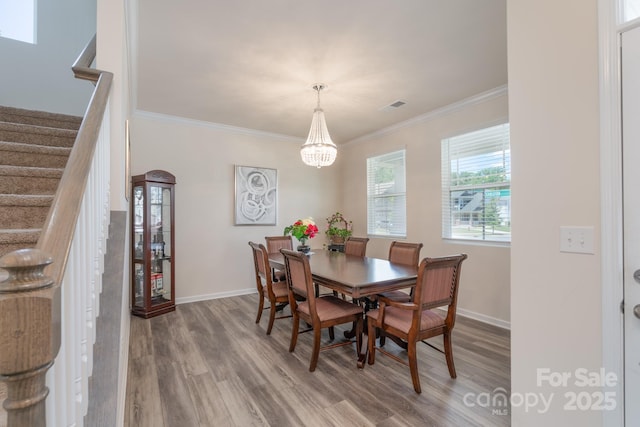 1004 Earlston Rd, Indian Trail, NC 28079 - dining space featuring wood finished floors, stairway, crown molding, a chandelier, and baseboards