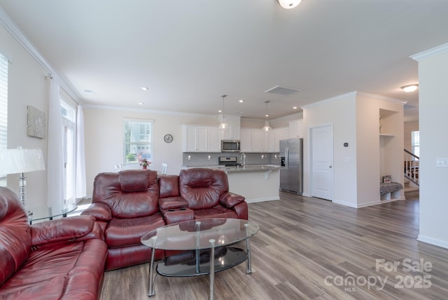 1004 Earlston Rd, Indian Trail, NC 28079 - living room featuring crown molding, light wood-style flooring, stairs, baseboards, and recessed lighting