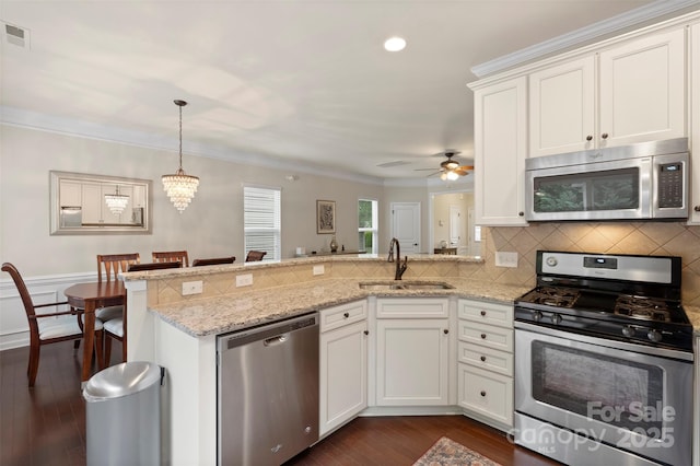 4278 Park S Station Blvd, Charlotte, NC 28210 - kitchen with appliances with stainless steel finishes, a peninsula, a sink, ornamental molding, and a ceiling fan