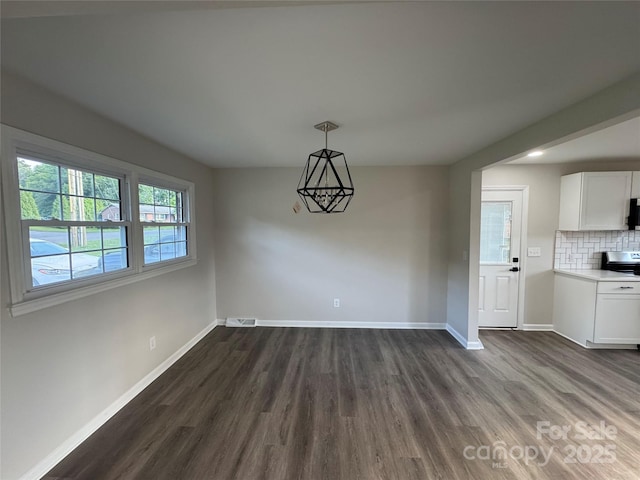 1735 Hollandale Dr, Gastonia, NC 28054 - unfurnished dining area with dark wood finished floors, baseboards, and a chandelier