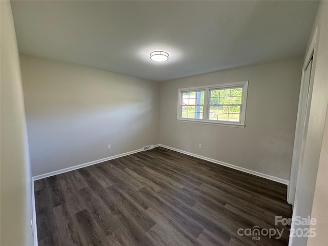 1735 Hollandale Dr, Gastonia, NC 28054 - unfurnished bedroom with dark wood finished floors, baseboards, and a closet