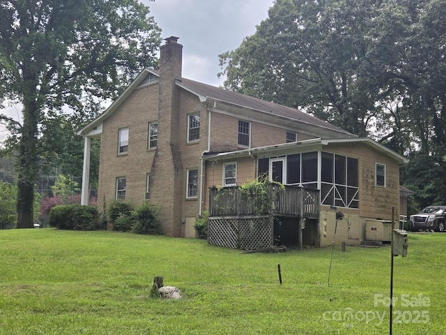 9225 Robinson Church Rd, Charlotte, NC 28215 - back of property featuring a sunroom, a chimney, a lawn, a deck, and brick siding