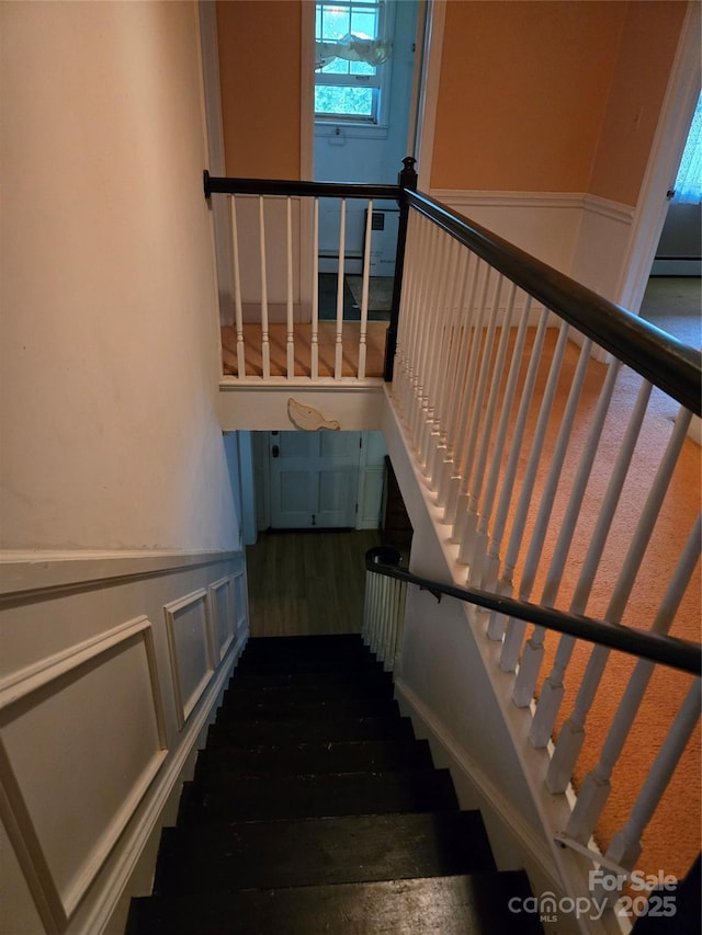 9225 Robinson Church Rd, Charlotte, NC 28215 - staircase featuring wainscoting, wood finished floors, and a baseboard heating unit