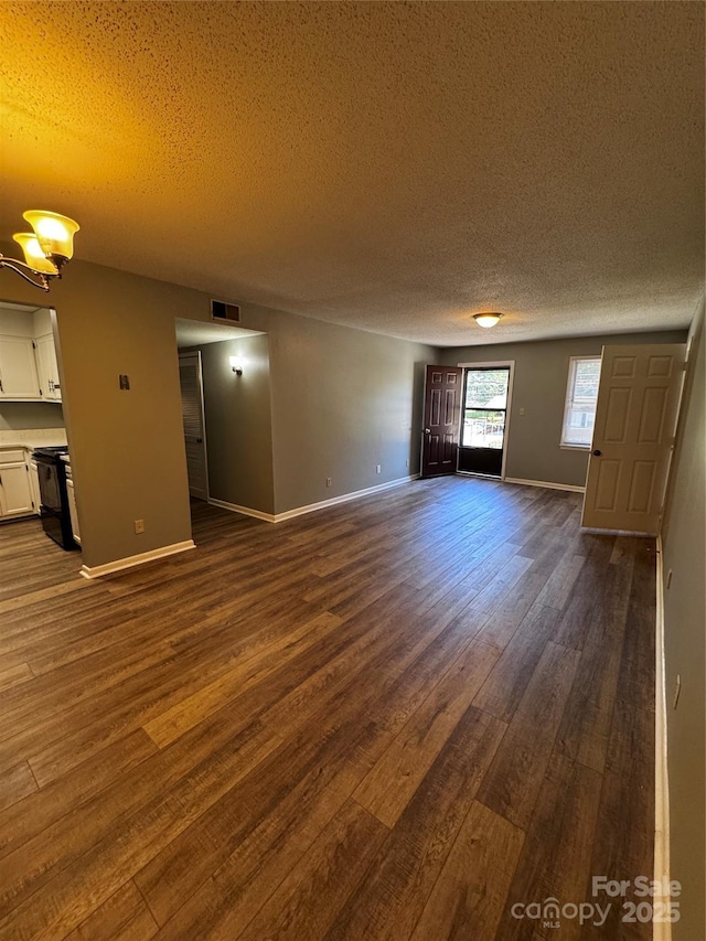 2106 S Main St, Kannapolis, NC 28081 - unfurnished living room with a textured ceiling, dark wood-style flooring, and baseboards