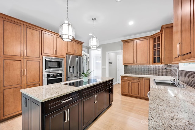 12711 Duncourtney Ln, Charlotte, NC 28277 - kitchen with a sink, appliances with stainless steel finishes, a kitchen island, tasteful backsplash, and brown cabinets