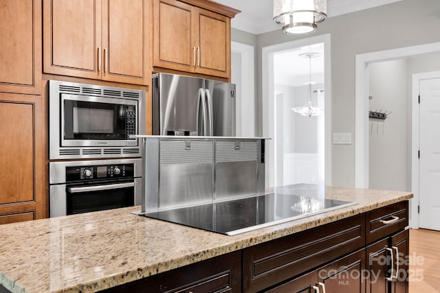 12711 Duncourtney Ln, Charlotte, NC 28277 - kitchen with stainless steel appliances, a chandelier, ornamental molding, light stone counters, and light wood-type flooring