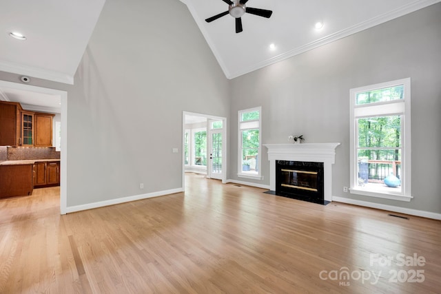 12711 Duncourtney Ln, Charlotte, NC 28277 - unfurnished living room featuring high vaulted ceiling, crown molding, a premium fireplace, a ceiling fan, and light wood-style floors