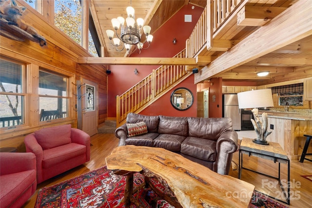 339 Tsalagi Trl, Maggie Valley, NC 28751 - living area with stairs, wood walls, a chandelier, wood finished floors, and wooden ceiling with exposed beams