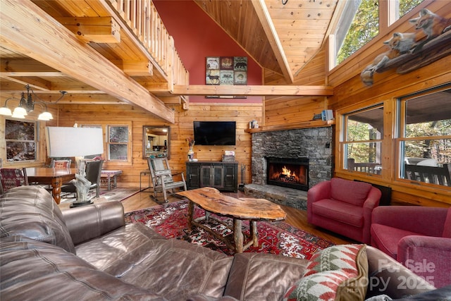 339 Tsalagi Trl, Maggie Valley, NC 28751 - living area with wood-type flooring, wooden walls, a stone fireplace, wooden ceiling, and a chandelier