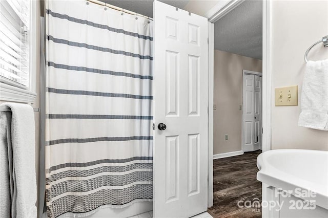 137 Weaver Ct, Lake Lure, NC 28746 - bathroom with wood finished floors, a textured ceiling, baseboards, and curtained shower