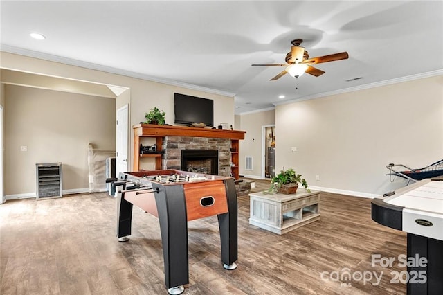 137 Weaver Ct, Lake Lure, NC 28746 - game room featuring a stone fireplace, a ceiling fan, baseboards, ornamental molding, and wood finished floors