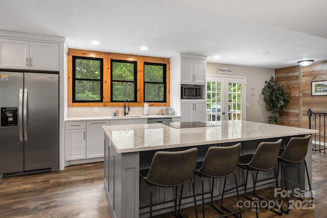 137 Weaver Ct, Lake Lure, NC 28746 - kitchen with appliances with stainless steel finishes, a kitchen island, light stone countertops, a breakfast bar, and recessed lighting