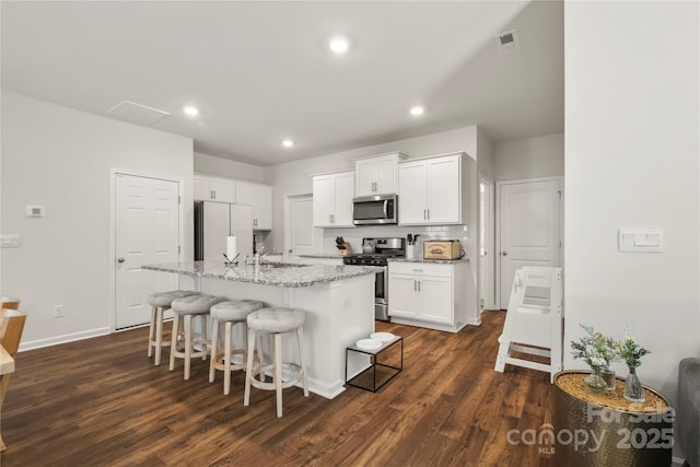 461 Misty Law Ln, Clover, SC 29710 - kitchen featuring appliances with stainless steel finishes, dark wood-style flooring, a breakfast bar, white cabinets, and recessed lighting